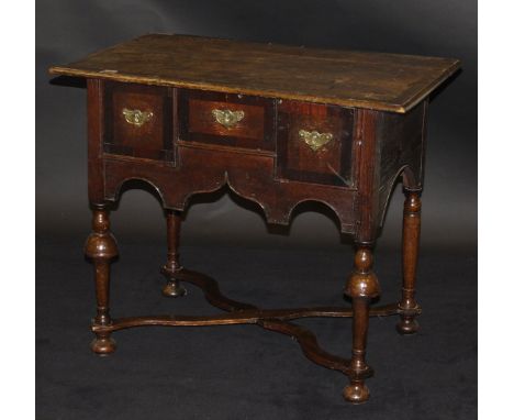 An 18th Century North Country oak and walnut cross-banded lowboy, the top with moulded edge over three drawers with replaceme