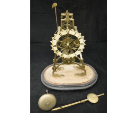 A Victorian brass skeleton clock with Roman numerals to the painted dial