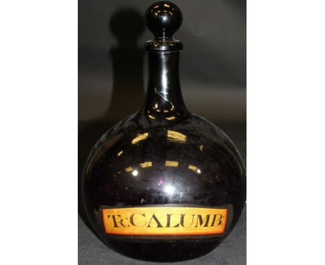 A 19th Century amethyst glass drug jar with ball shaped stopper, cylindrical neck and ovoid body bearing paper label "Tr: Cal