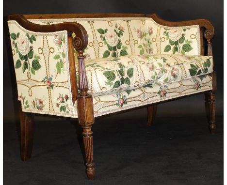 A Regency mahogany framed two seat salon sofa, the frame with reeded decoration, the scroll arms on turned tapering and reede