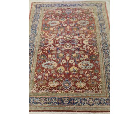 A Ziegler designed carpet, the central panel set with all-over floral design on a red ground, within a stepped red, blue and 