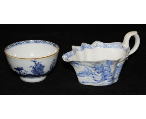 A circa 1750 Chinese export ware tea bowl decorated with blue house in a landscape on a white ground, raised on a footed base