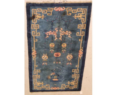 A Chinese Peking rug, the central panel set with Chinese lantern suspended from a central roundel above a flower-filled urn o