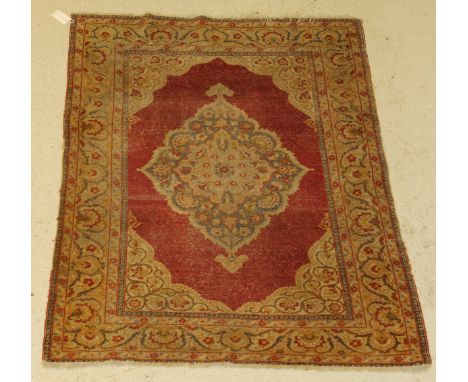 A Turkish carpet, the central panel set with floral decorated medallion on a red ground within a stepped red, fawn and golden