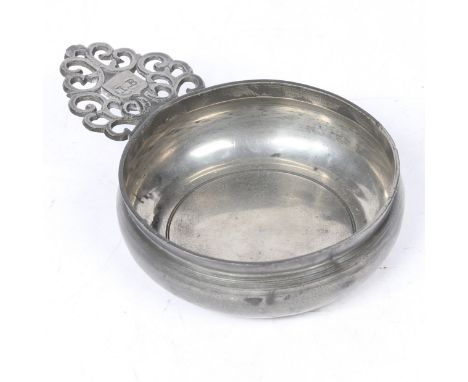 Having a peacock-tail ear, with ownership initials ‘I B’ and bar and wedge bracket, bellied bowl with flat base and footing, 