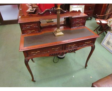 A late Victorian mahogany writing desk, the raised four drawer mirror back with carved pediment over two frieze drawers on ac