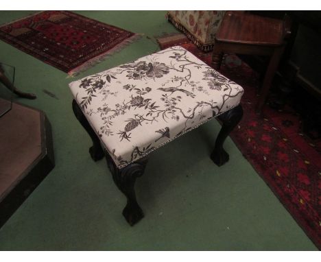 A 19th Century mahogany stool the upholstered seat over ball in claw carved cabriole legs with scroll decoration