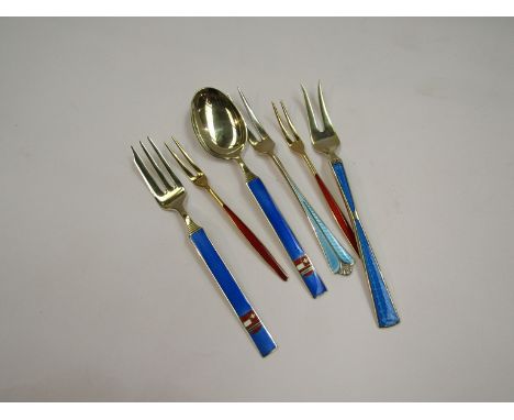 Six pieces of Norwegian silver-gilt and enamel including pickle fork, lemon forks and a cake fork and knife