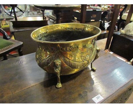 An antique brass planter on paw feet