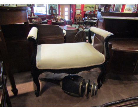A Victorian ebonised stool with carved decoration, the scroll arms over cabriole legs