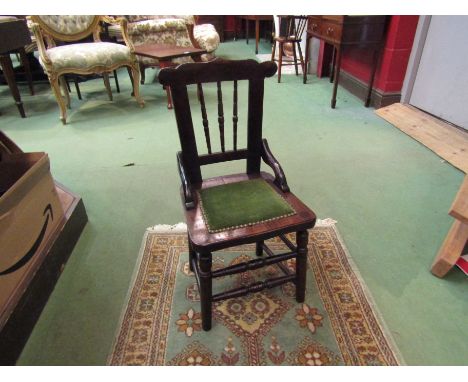 A late Victorian oak child's chair with spindle back over ring turned legs and stretchers