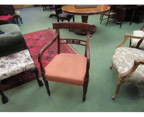 A George III mahogany elbow desk chair with carved and pierced back rest, the scroll arms over ring turned tapering legs