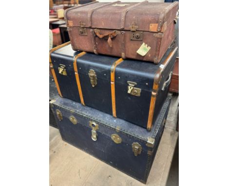 A banded steamer trunk, another steamer trunk and a banded suitcase