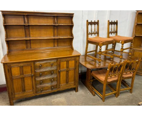 An Ercol Golden Dawn elm dining suite, comprising; refectory table, four chairs and a dresser