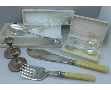 A pair of silver dwarf candlesticks, a pair of fish servers with silver ferrules, a pickle spoon and fork marked 830S and six