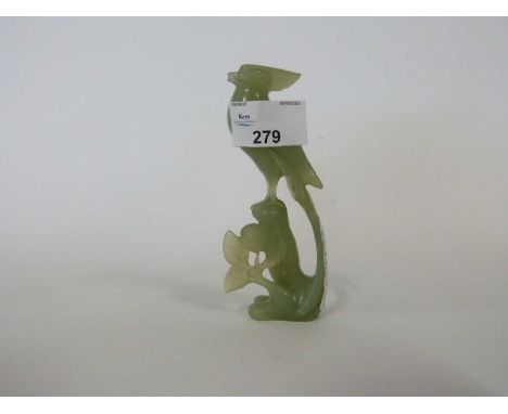 Jade model of a bird on a rock with carved flowers beneath, 12cm high