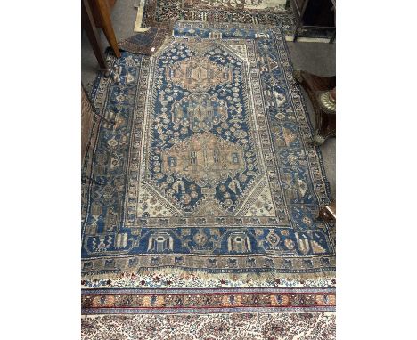 Antique Middle Eastern wool floor rug decorated with large central blue panel with geometric detail and stylised birds, 206 x