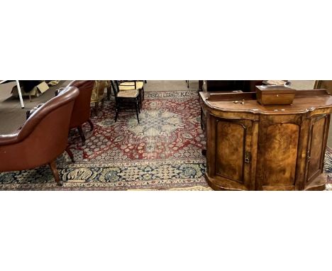 A 20th Century Middle Eastern wool floor rug decorated with a large central red panel surrounded by a five tier foliate borde