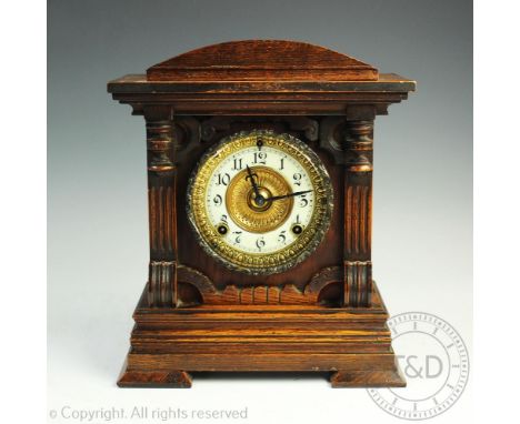 An Edwardian oak 8-day mantel clock, the architectural case enclosing a circular dial with enamelled chapter ring and black A