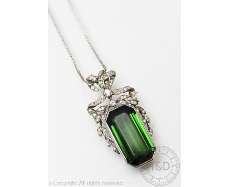 A tourmaline and diamond Belle Epoque pendant/brooch, designed as a large central, untested green tourmaline (measuring 25mm 