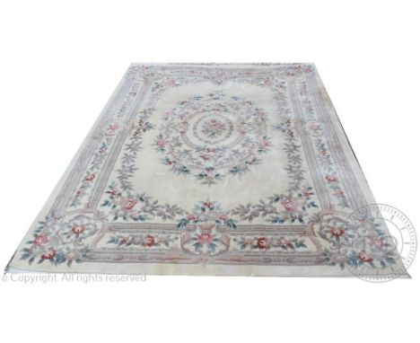 A Chinese wool carpet, worked with a floral design against an ivory ground, 380cm x 273cm