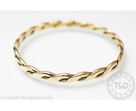 A yellow metal torque style bangle, of twisted form, unmarked, weight 25.8gms 