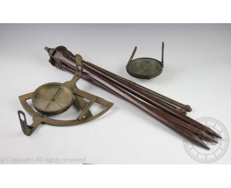 A late 19th/early 20th century lacquered brass surveyors compass and level, raised on a tri-pod stand and a further brass cas