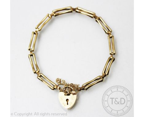 A deliate 9ct gold gate bracelet, designed as ten two bar links, with an attached heart shaped padlock clasp, weight 5.6gms 