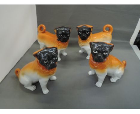 Two pairs of mid 20th century ceramic Pug dogs, seated and standing