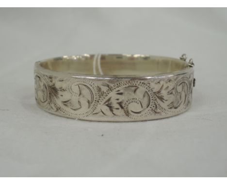 An HM silver silver hinged bangle having bright cut and engraved decoration
