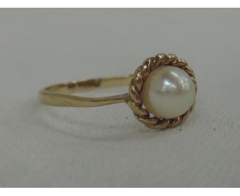 A ladies dress ring having a cultured pearl within a rope wire mount on a 9ct gold loop