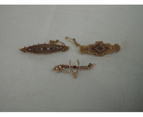 Three 9ct gold bar brooches of various forms including wishbone, ruby, and ruby and seed pearl,  approx 7.7g