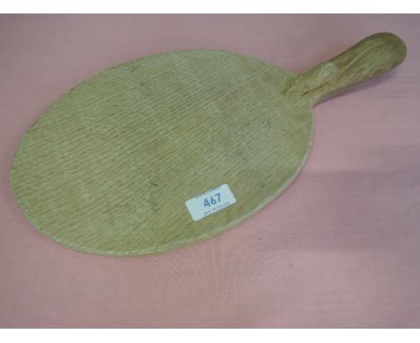 A light oak bread board in the Robert Thompson of Kilburn Mouseman style, of oval racket/bat shape having carved mouse motif