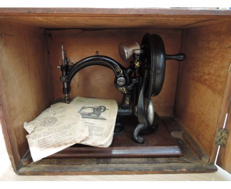 A late 19th century Wilcox & Gibbs hand 'silent' sewing machine with instruction leaflet and case