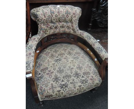 A late Victorian mahogany tub armchair having foliate carved decoration and 20th century tapestry upholstery on short turned 