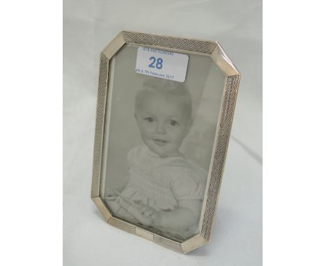 A silver photograph frame of rectangular form having canted corners and engine turned decoration, Birmingham 1927, J W Tiptaf