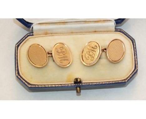 A pair of 9ct gold oval cufflinks with engine-turned decoration and engraved initials, 15.2g, boxed.