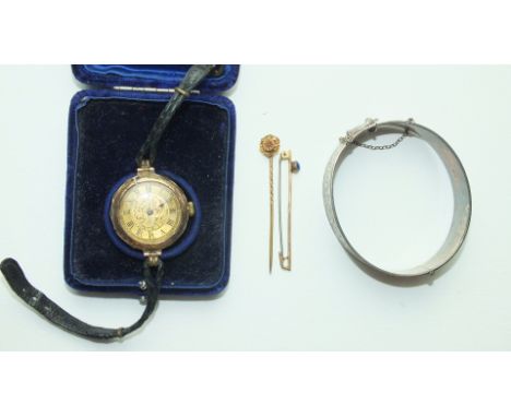 A 1960's silver hinged bangle, a gold-cased wrist watch, (a/f), a gold bar brooch and a stick pin set diamond point, (4).