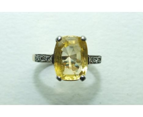 An Edwardian yellow sapphire and diamond ring, claw-set an oval yellow sapphire between 8/8-cut diamond-set shoulders, in 18c