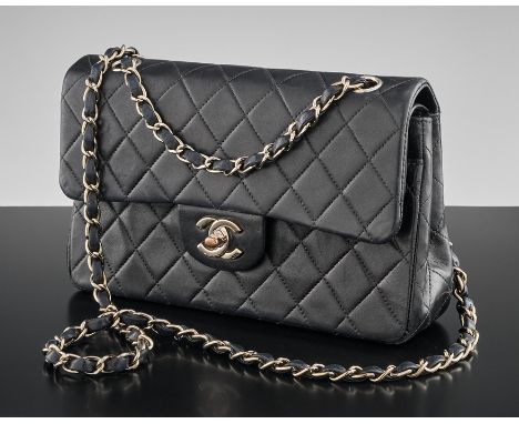 Chanel Classic Flap Bag. Schwarzes Kalbleder mit Zierstempelung. Tragekette. Dunkelrotes Innenfutter. Silberfarbene Metalltei