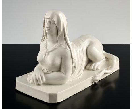 Liegende Sphinx als Briefbeschwerer. Auf oktogonaler Plinthe, die Vorderpfoten gekreuzt. Kopftuch und Haarzöpfe. Weiß glasier