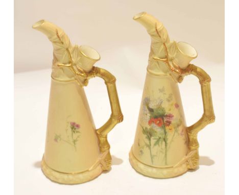 Pair of late 19th century Royal Worcester ewers, the blush ground decorated with flowers with gilt faux bamboo handles, Worce