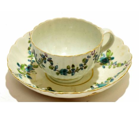 18th century Worcester porcelain cup and saucer decorated with swags of flowers in green enamel, the saucer 14cm diam
