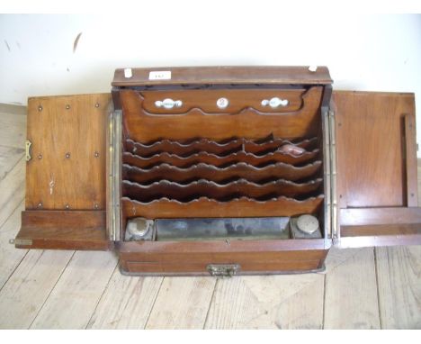 Edwardian country house style table top stationary cabinet enclosed by two slope front doors revealing fitted interior with d