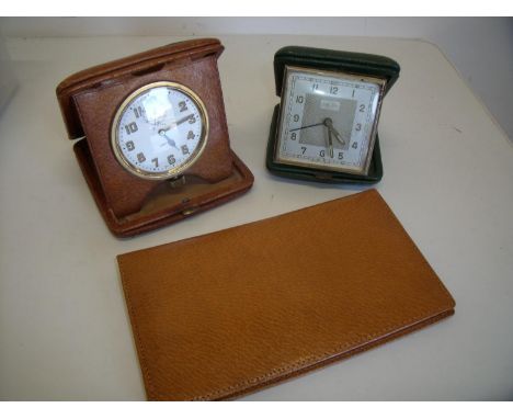 Leather cased travelling 8 day clock, a tan leather aid memoir and another traveling clock (3) 