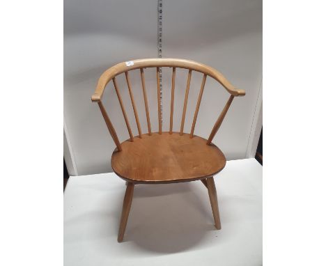 A Ercol cowhorn fireside chair in beech and elm