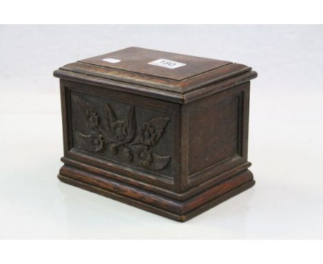 Carved hardwood tea caddy with floral decoration in relief, mirror to interior, height approximately 15cm