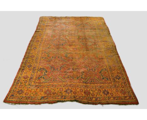 Ushak carpet, west Anatolia, about 1920s, 14ft. 7in. x 10ft. 3in. 4.45m. x 3.12m. Overall wear, heavy in places; some holes; 