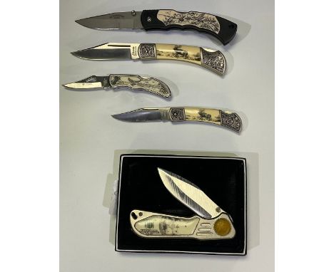 Collection of presentation knifes of various sizes with scrimshaw style etching including stags, eagles, ducks and dollar bil