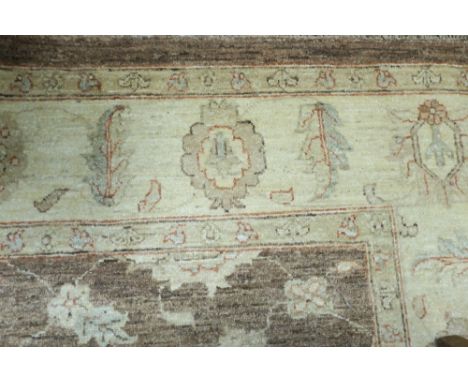 A WOOL RUG the light brown and beige ground with central floral panel with a conforming border 270cm x 179cm 
